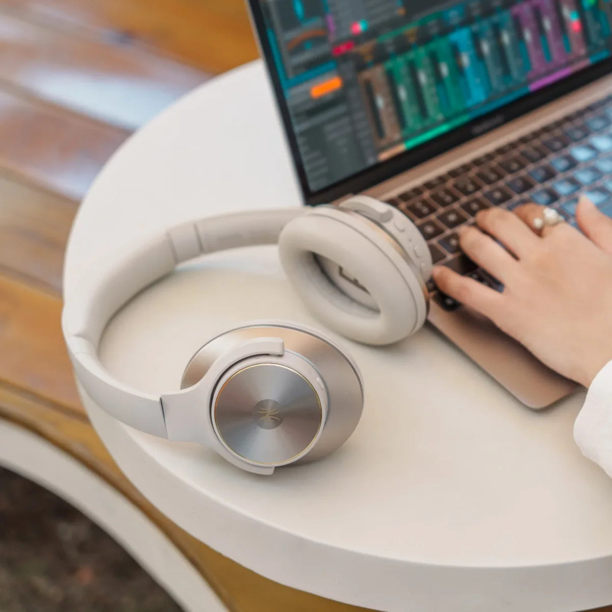 Original listing photograph of the silver Oneodio headphones beside a laptop